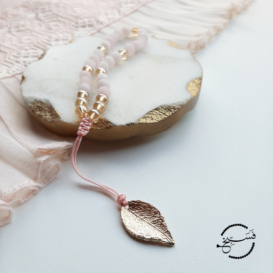 Rose quartz and gold beads, with a brass leaf.  Features an adjustable knot.  33 beads (6mm beads)