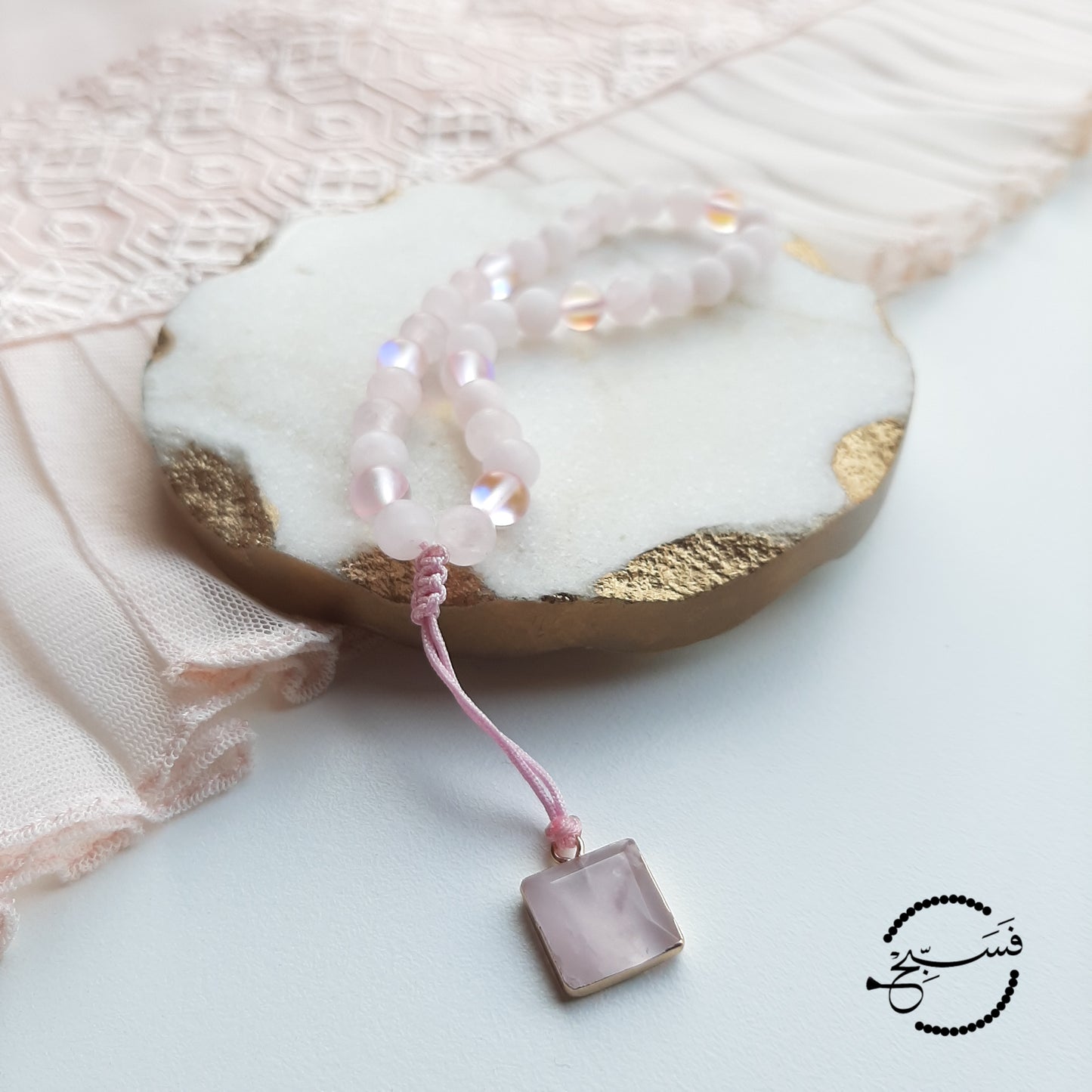 Rose quartz and moonstone beads, with a rose quartz pendant. Features an adjustable knot. 33 beads (6mm beads)
