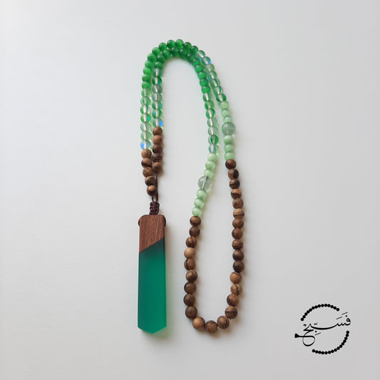 Green cat eye, moonstone, and wood beads with a resin and wood pendant. Packaged in a luxurious pouch and a gift box. 99 beads