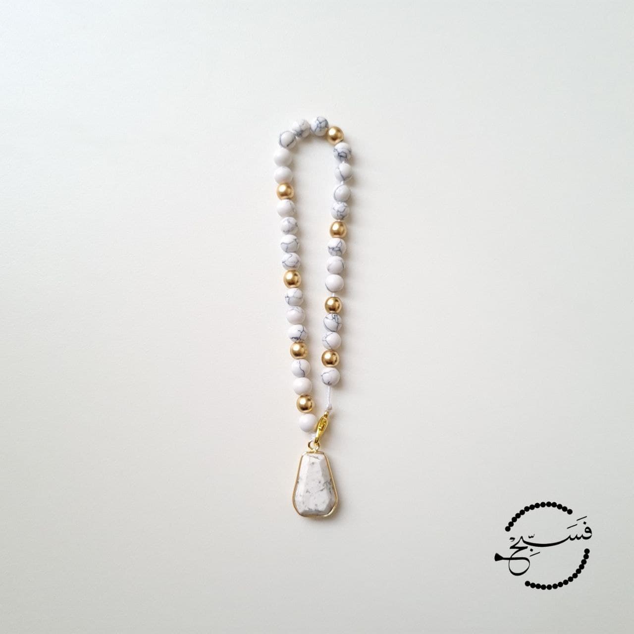 Stunning white howlite & matte gold beads paired with a white howlite pendant. 33 bead tasbih that can be clipped onto your bag. Packaged in a luxurious pouch and a gift box.