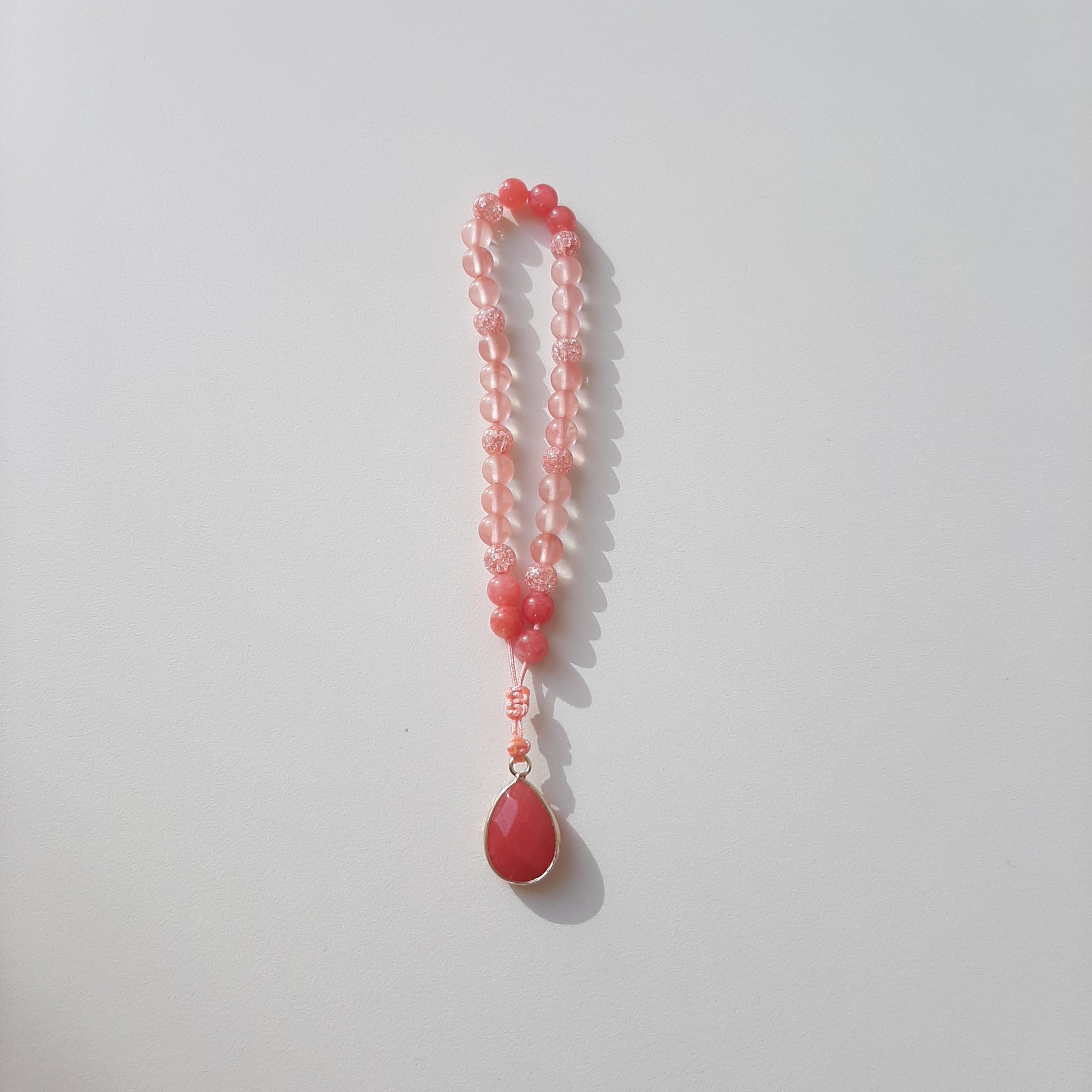 Watermelon quartz and coral beads, with a watermelon quartz pendant.  Features an adjustable knot.  33 beads (6mm beads)