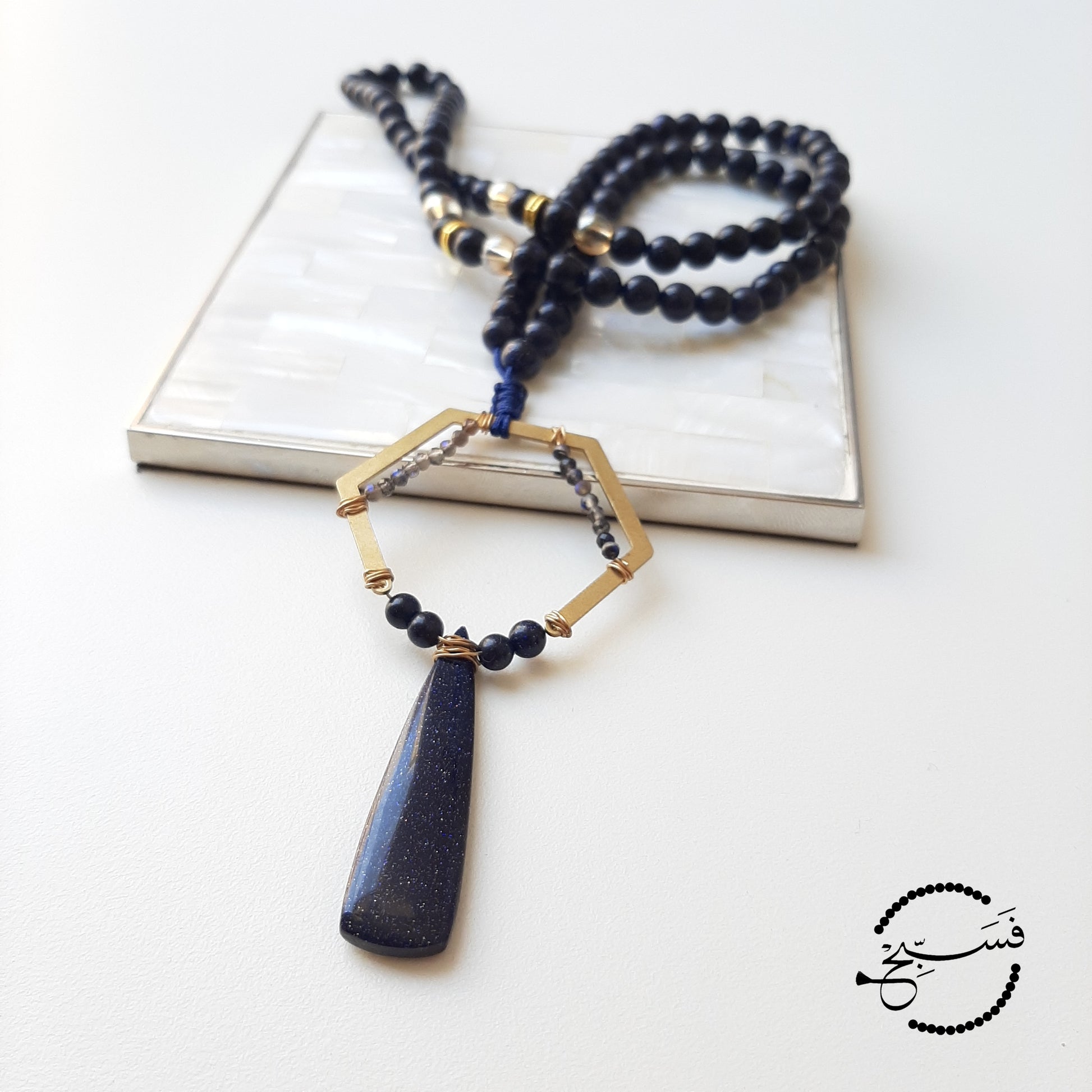 Dramatic. Dark blue sandstone, which is almost glittery, is used throughout this design, except for the tiny beads, which are obsidian.   Packaged in a luxurious pouch and a gift box.  99 beads