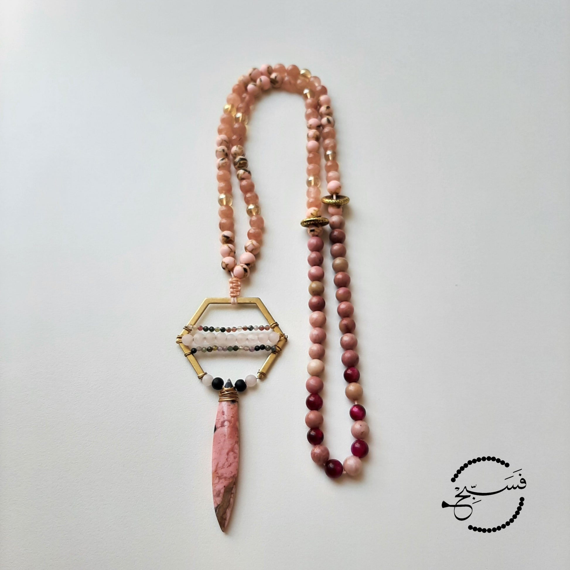 Natural rhodonite stone which has a beautiful shape and feel. Handcrafted to form a unique and intricate pendant with mini rose quartz and tourmaline beads.  Packaged in a luxurious pouch and a gift box.  99 beads