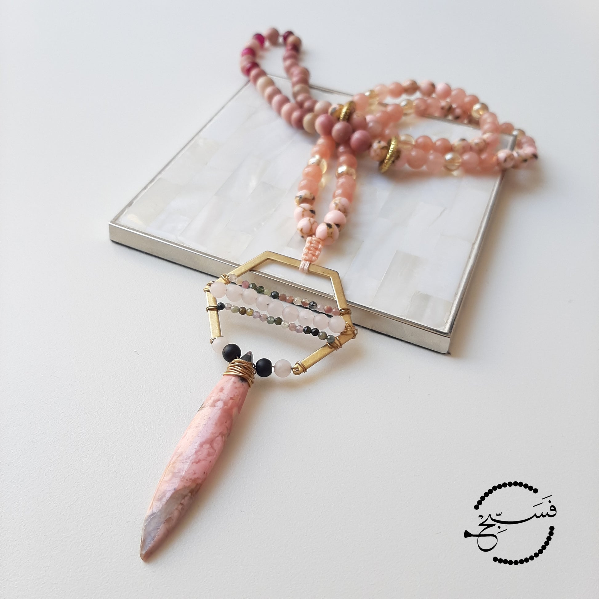 Natural rhodonite stone which has a beautiful shape and feel. Handcrafted to form a unique and intricate pendant with mini rose quartz and tourmaline beads.  Packaged in a luxurious pouch and a gift box.  99 beads