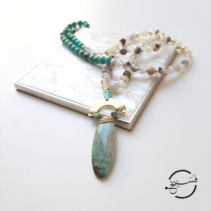 Made using sea sediment and agate beads completed with a chrysocolla stone pendant.  Packaged in a luxurious pouch and a gift box.  99 beads
