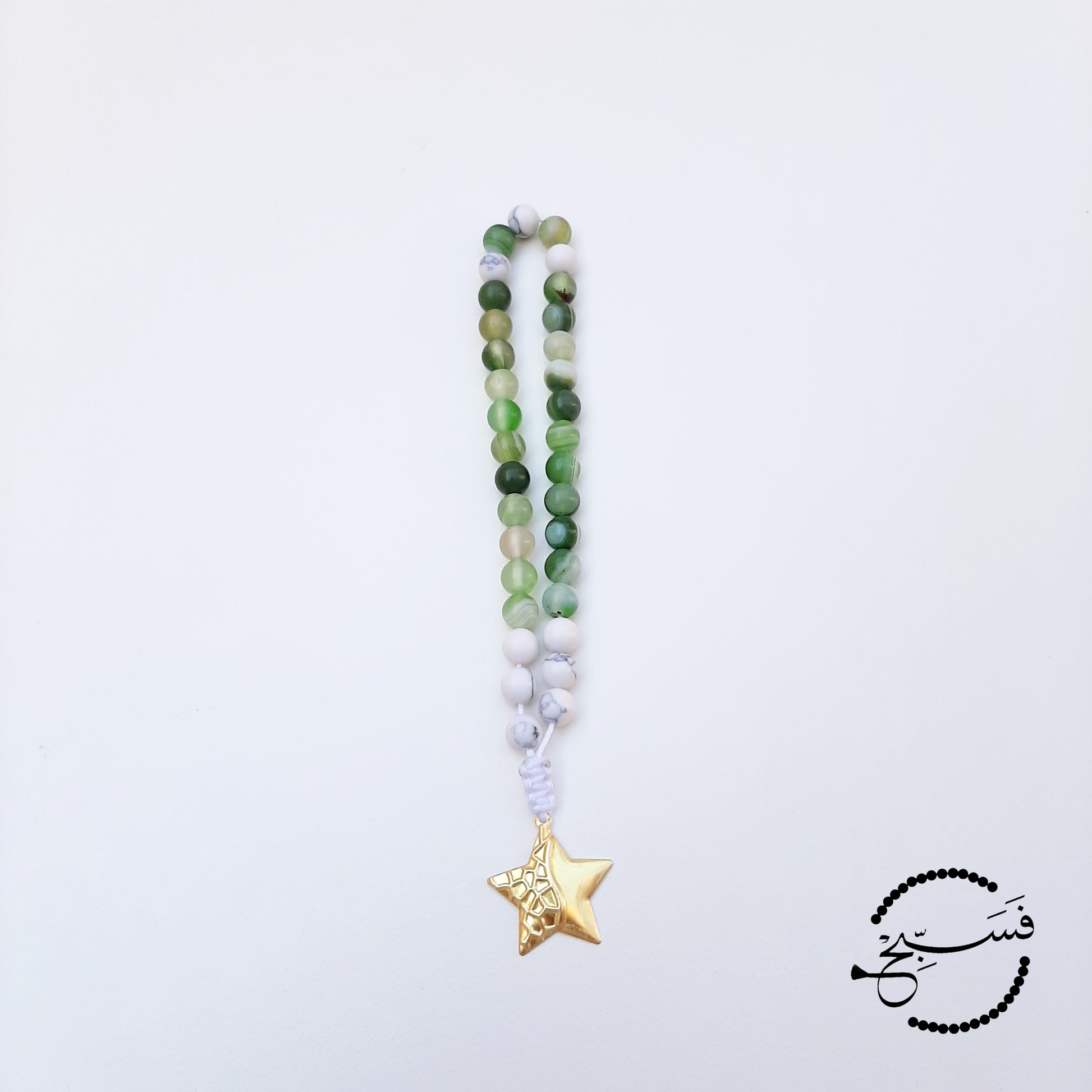 Green agate and white howlite beads, with a brass star pendant.  33 beads