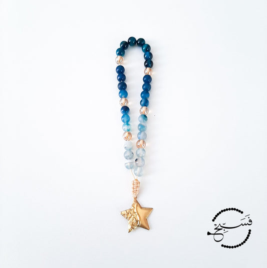 Blue agate and tiger eye beads with a brass star pendant.  33 beads.