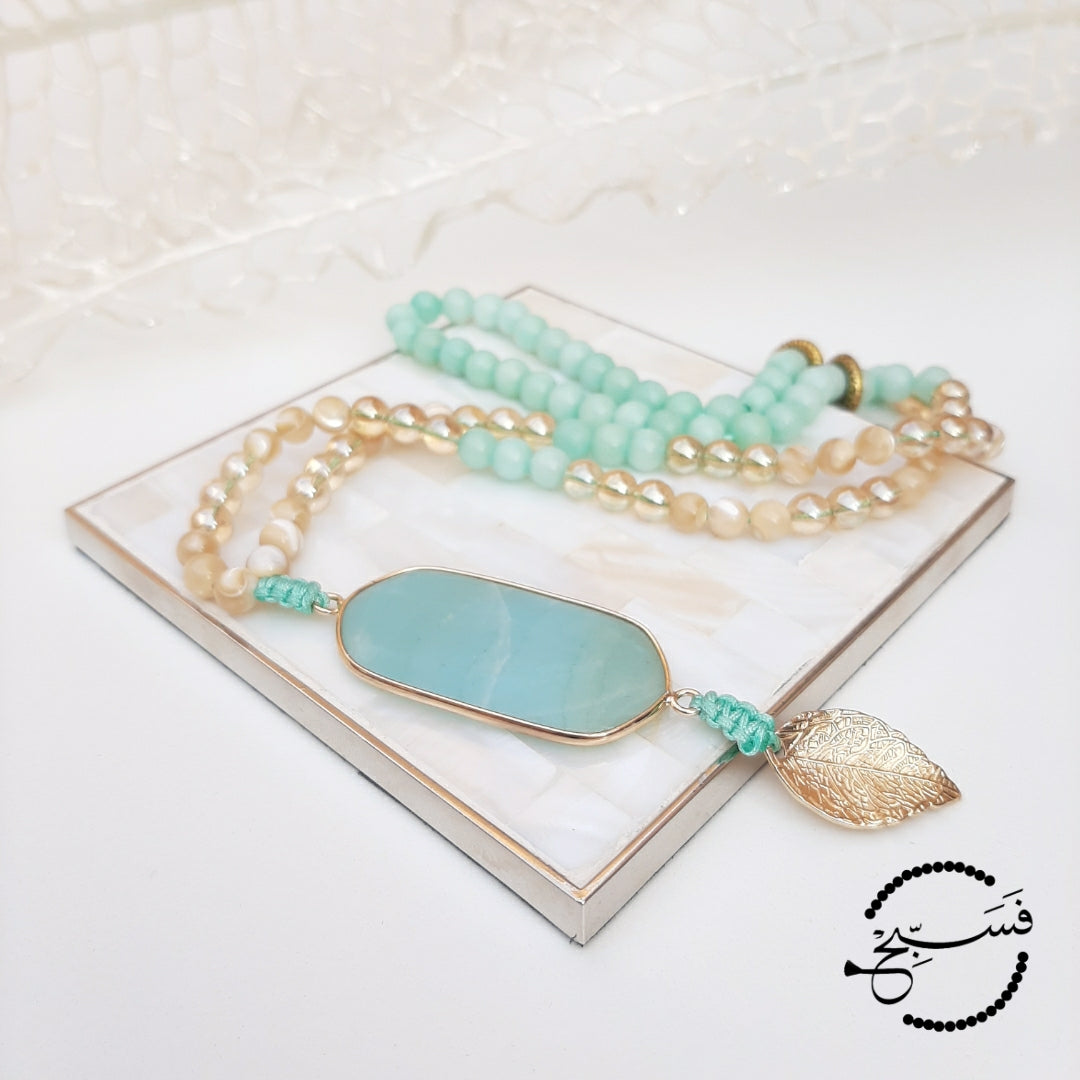 Amazonite. Dreamy shades of turquoise. Here we have used the lighter shade of amazonite with gold and natural trochus shell beads. Finished with an amazonite pendant and a gold leaf.  Packaged in a luxurious pouch and a gift box.  99 beads