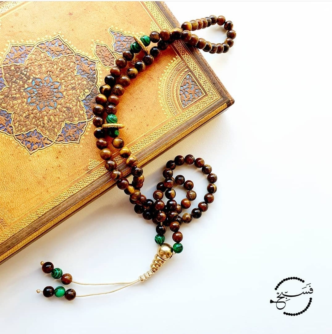 Natural brown tiger eye beads with a hint of green malachite. This piece is tied together with a copper three-way bead. Features an adjustable string length.  Packaged in a luxurious pouch and a gift box.  99 beads