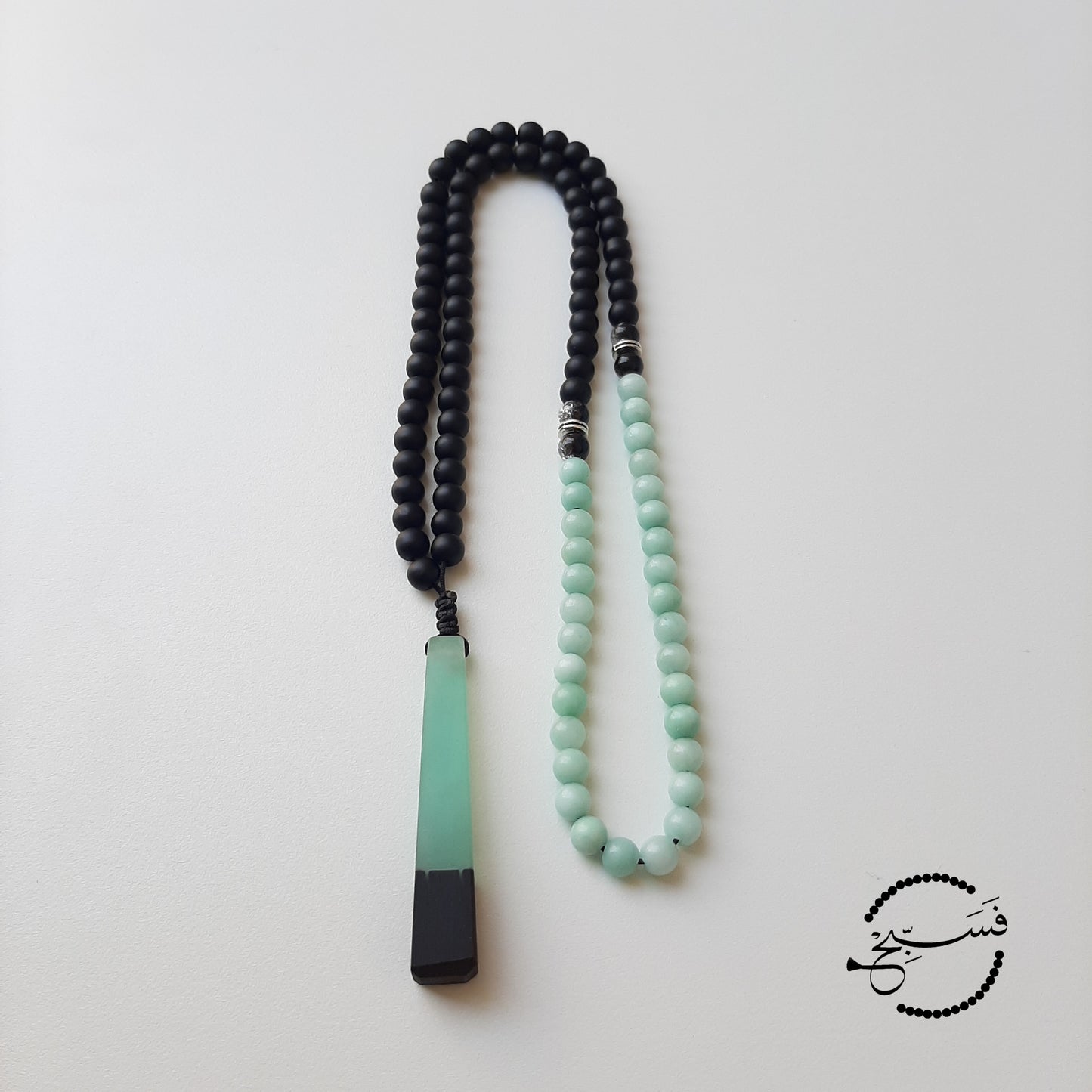 Amazonite and matte black beads, with a hint of silvery crystal beads and a resin pendant.  Packaged in a luxurious pouch and a gift box.  99 beads
