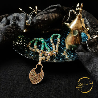 This pendant is reminiscent of Islamic designs in both shape and pattern. The abalone is complemented by the sea sediment and smoky quartz beads.  Packaged in a luxurious pouch and a gift box.  99 beads