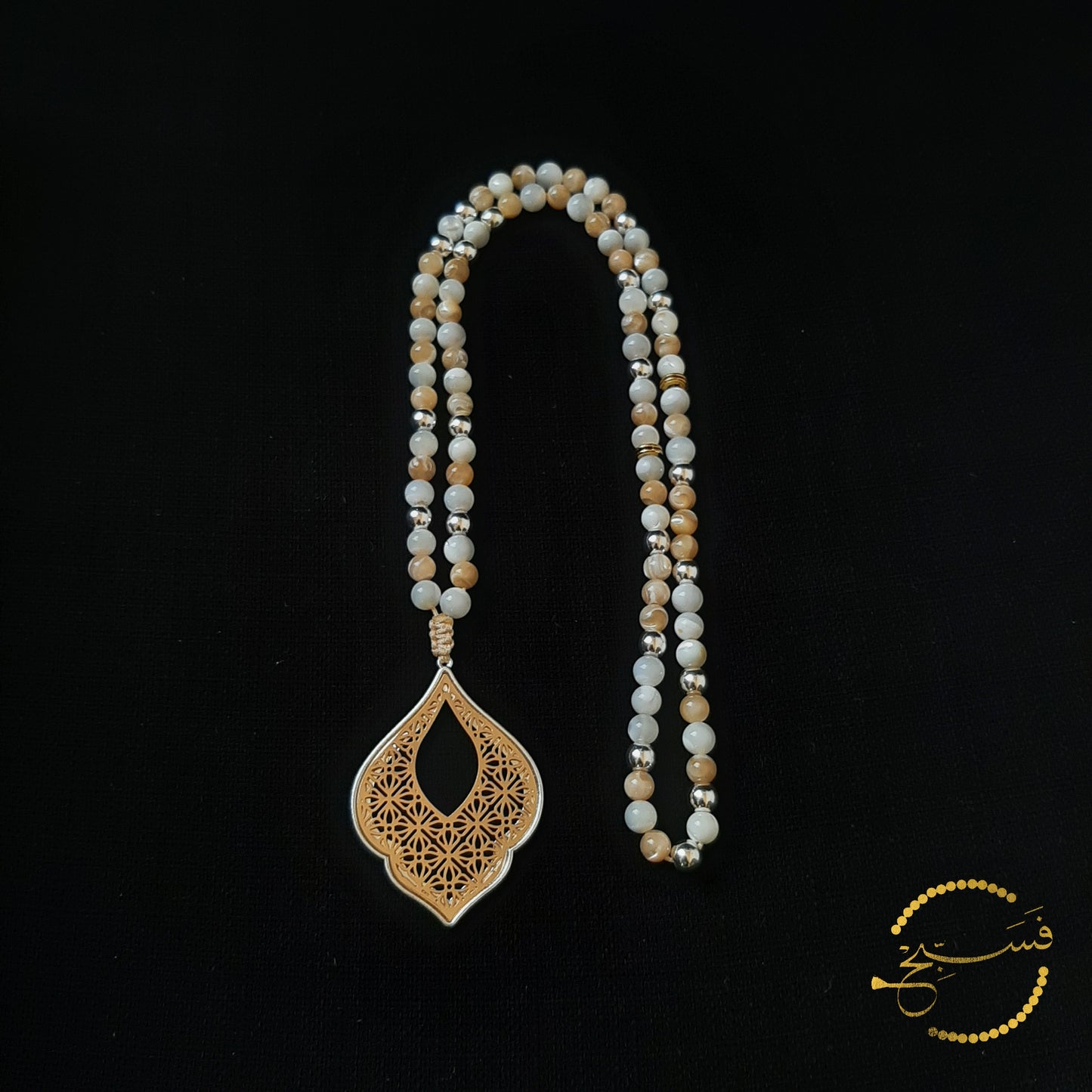 A pendant reminiscent of Islamic design, this tasbih has a gold & silver effect with the use of natural trochus shell and hematite beads.  Packaged in a luxurious pouch and a gift box.  99 beads.