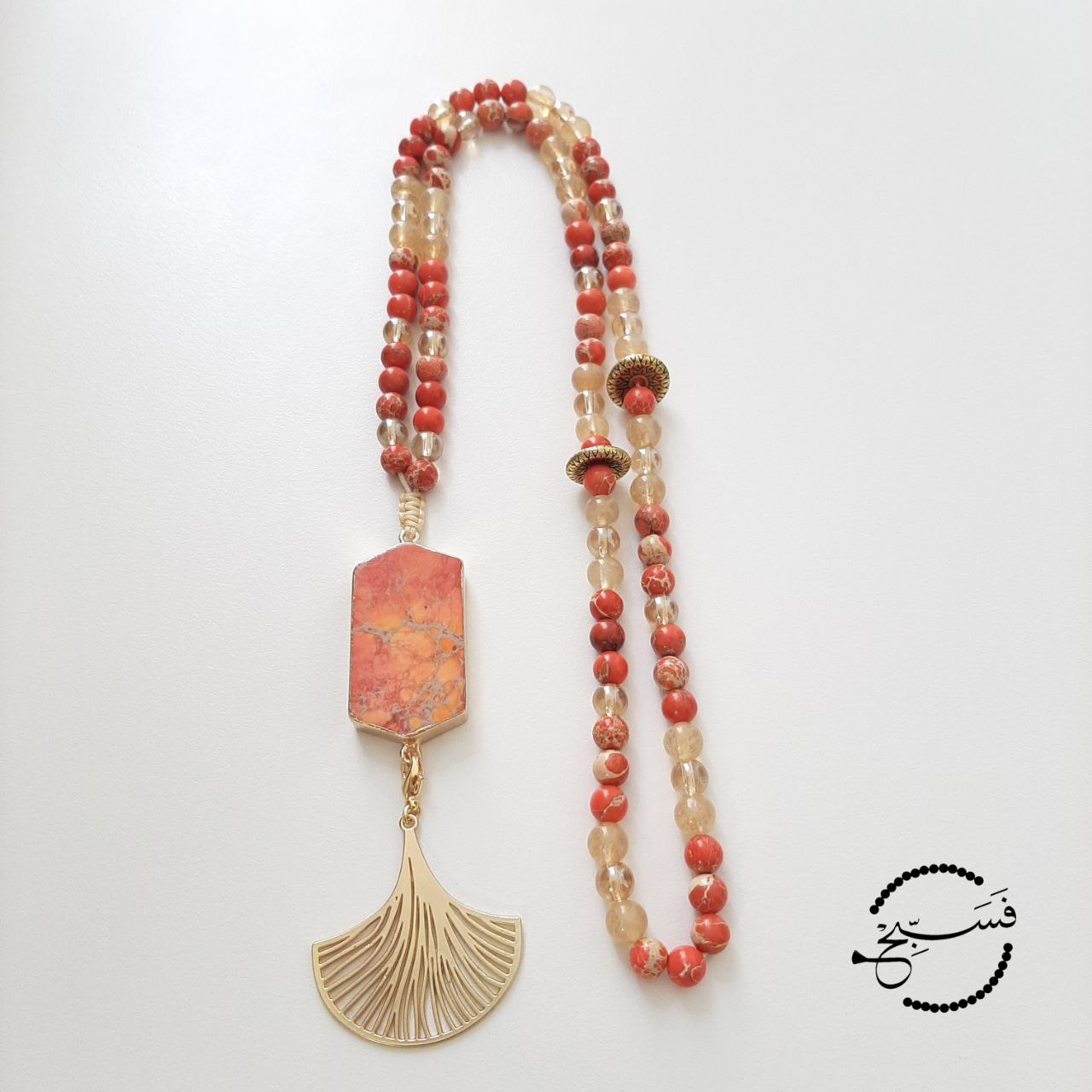 Orange sea sediment beads and pendant.  This unique piece features interchangeable pendants - you can choose between a striking orange tassel or a classic gold fan.  Packaged in a luxurious pouch and a gift box.  99 beads