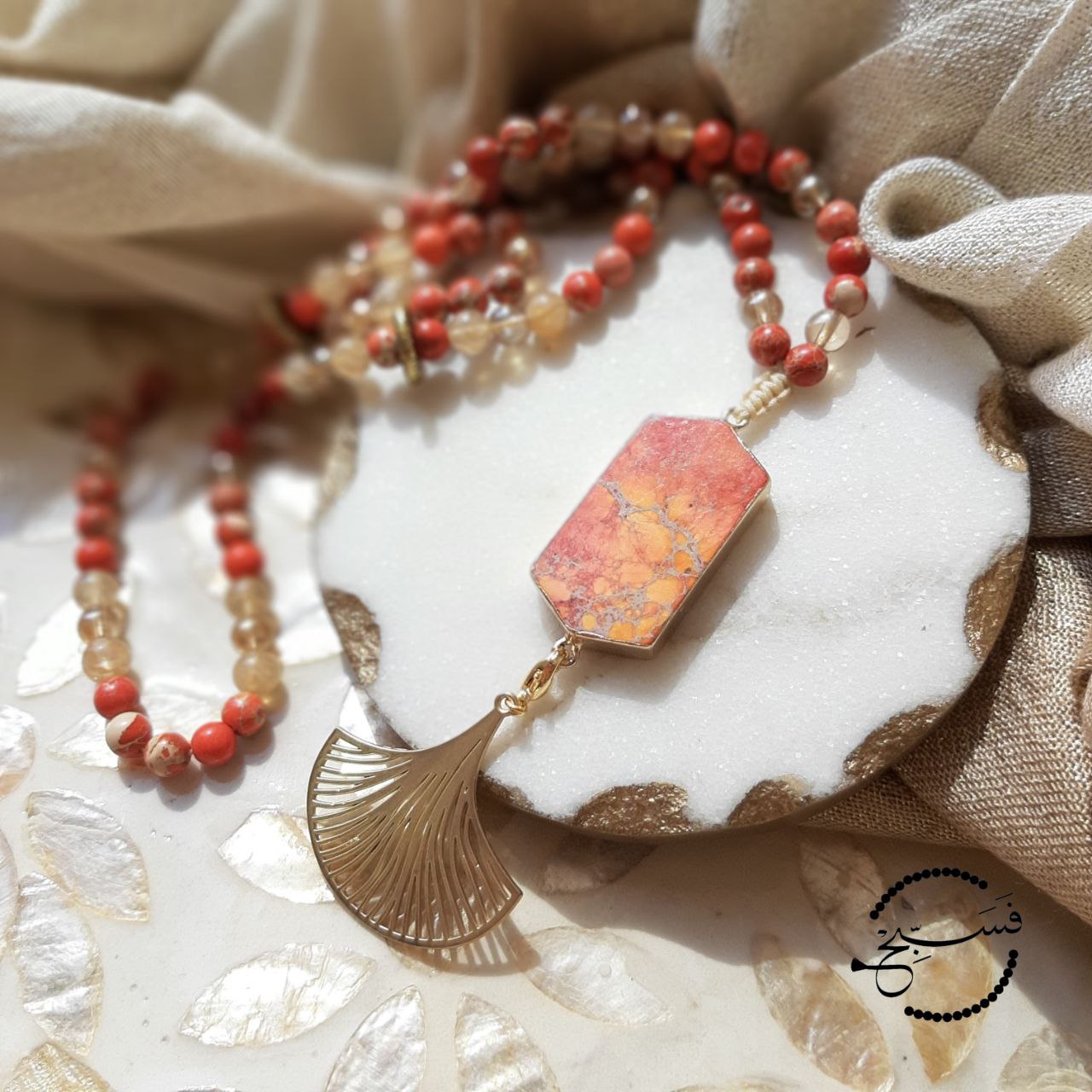 Orange sea sediment beads and pendant.  This unique piece features interchangeable pendants - you can choose between a striking orange tassel or a classic gold fan.  Packaged in a luxurious pouch and a gift box.  99 beads