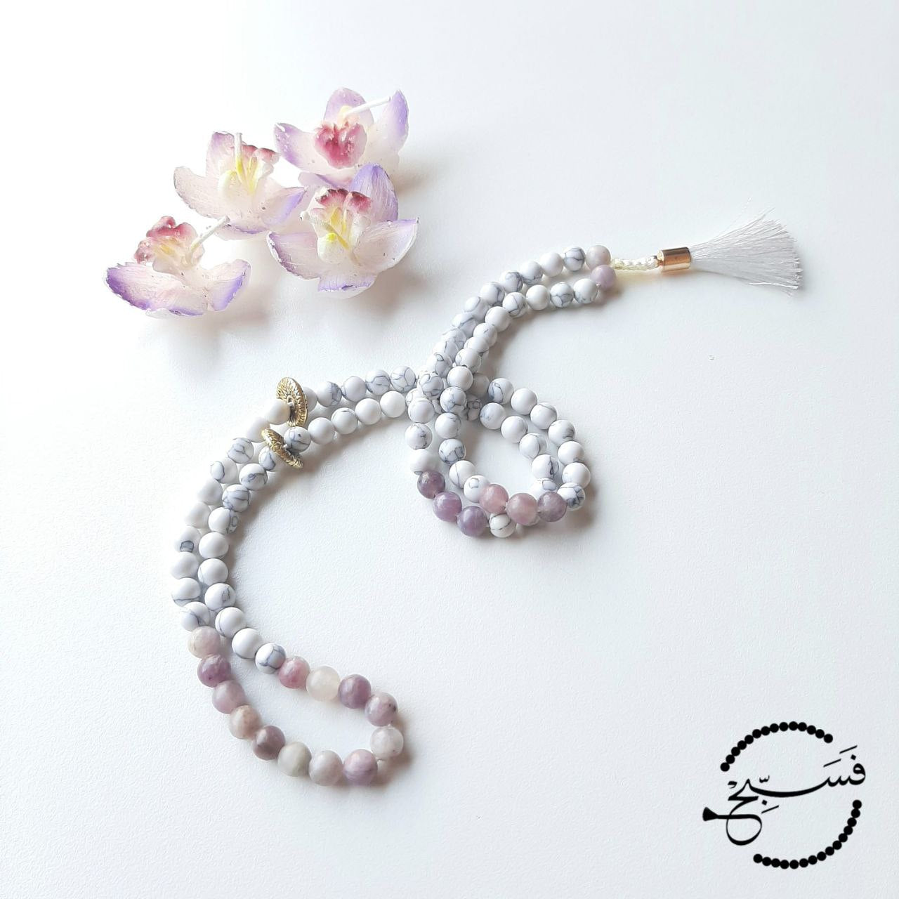 White howlite and lilac jasper, simply tied with a white silk tassel.  Packaged in a luxurious pouch and a gift box.  99 beads