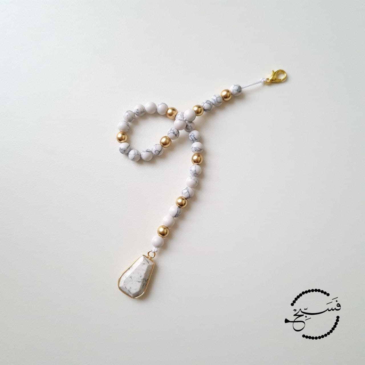 Stunning white howlite & matte gold beads paired with a white howlite pendant.   33 bead tasbih that can be clipped onto your bag.   Packaged in a luxurious pouch and a gift box.