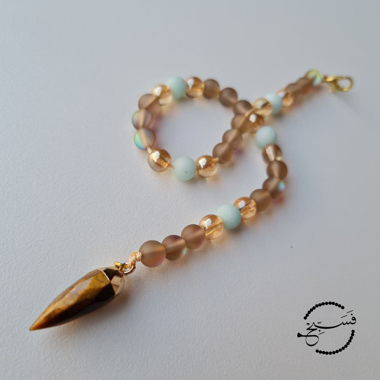 This bag charm features a tiger eye pendant with coffee coloured moonstone and amazonite beads.   33 bead tasbih that can be attached to your bag.   Packaged in a luxurious pouch and a gift box.