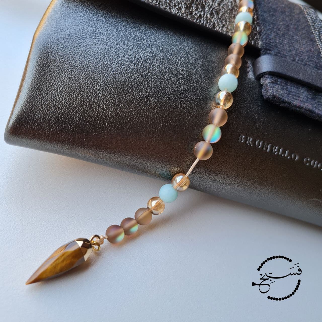 This bag charm features a tiger eye pendant with coffee coloured moonstone and amazonite beads.   33 bead tasbih that can be attached to your bag.   Packaged in a luxurious pouch and a gift box.